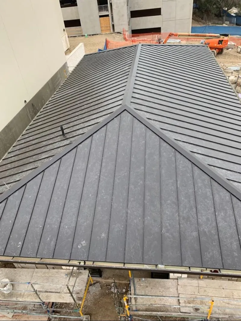 Commercial metal roof construction with crane equipment in Rockland